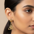 Close-up of 925 silver golden aura triangle leaf drop earrings worn on ear showcasing geometric triangular silhouette