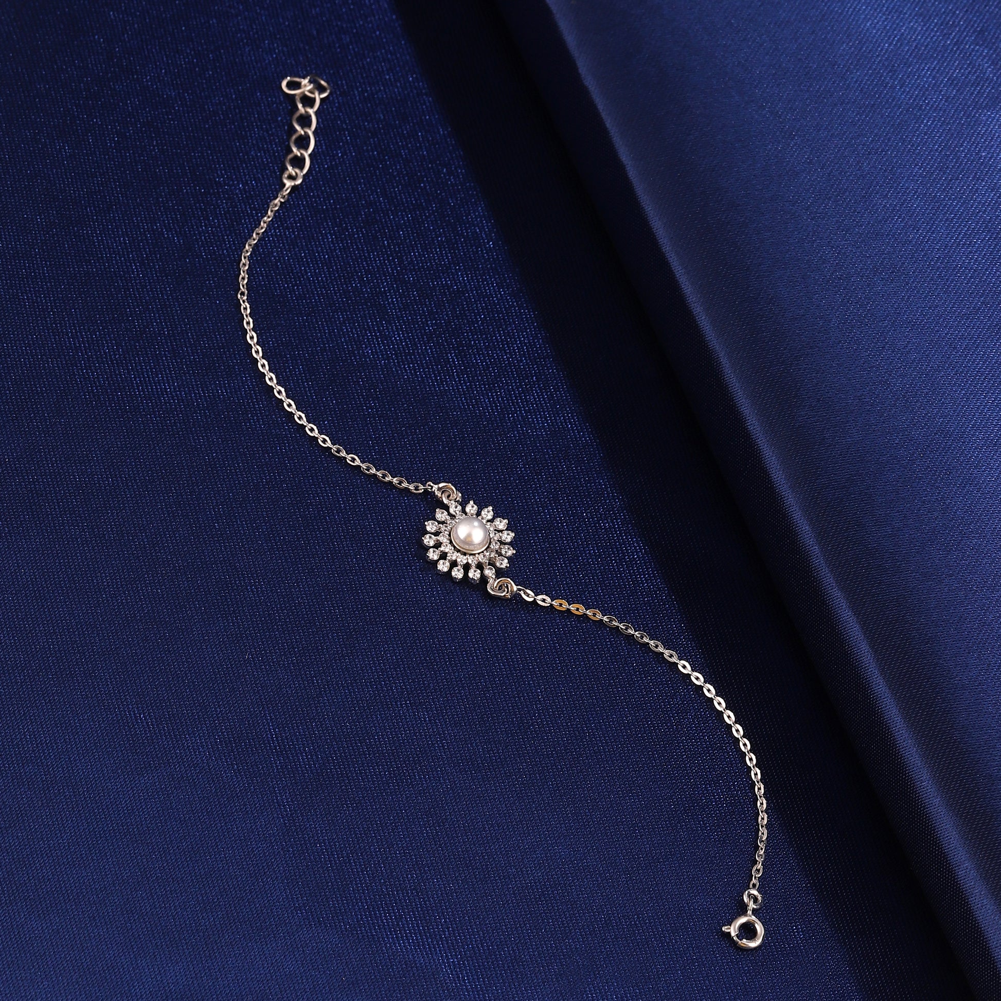 925 silver sunflower pearl bracelet on blue fabric background