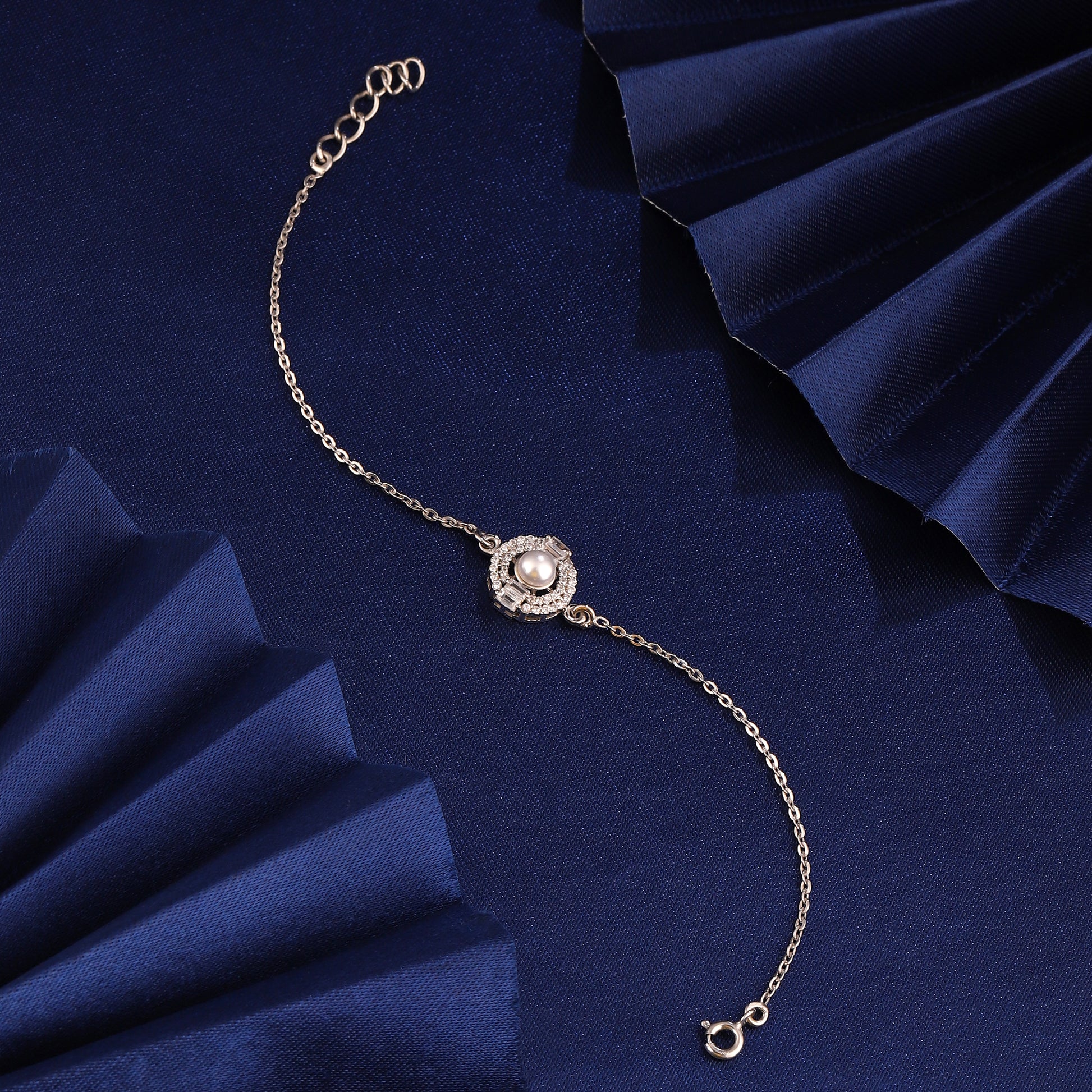 925 silver pearl halo bracelet styled on blue fabric background