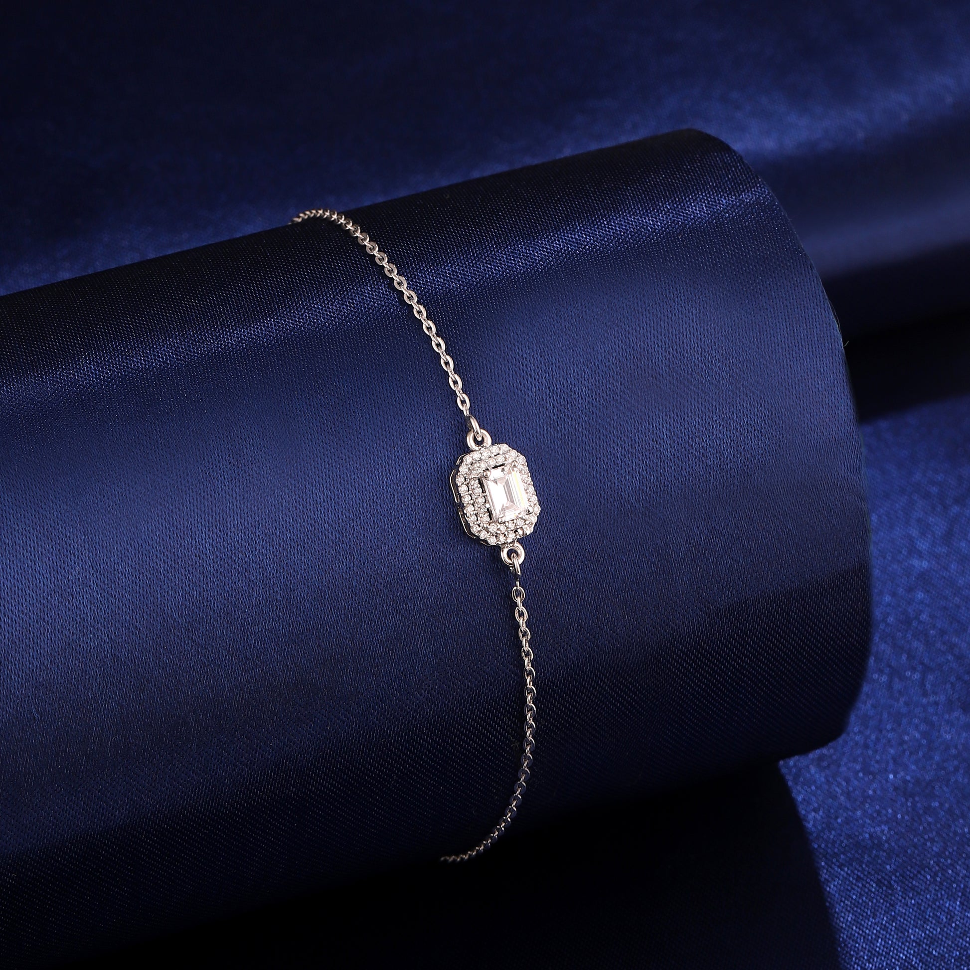 925 silver emerald-cut halo bracelet styled on dark blue background