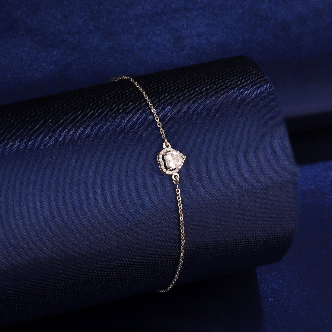 925 silver heart-shaped halo bracelet styled on dark blue background