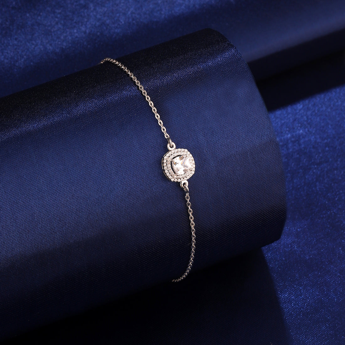 925 silver cushion halo bracelet styled on dark blue background