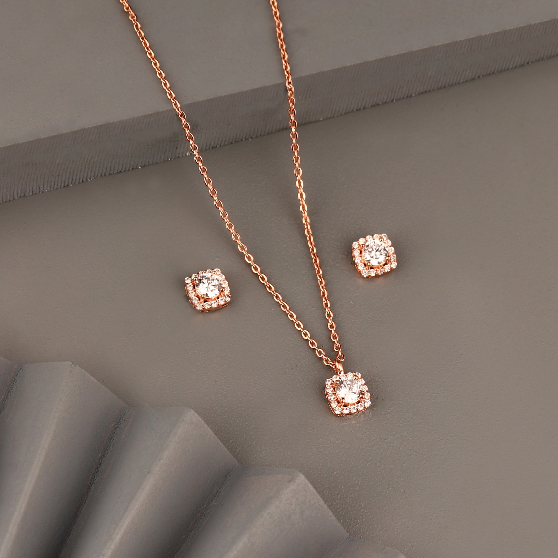 Rose gold cushion halo pendant set in 925 silver with sparkling stones on grey background