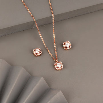 Rose gold pendant set in 925 silver with round center stone and geometric halo design including matching stud earrings