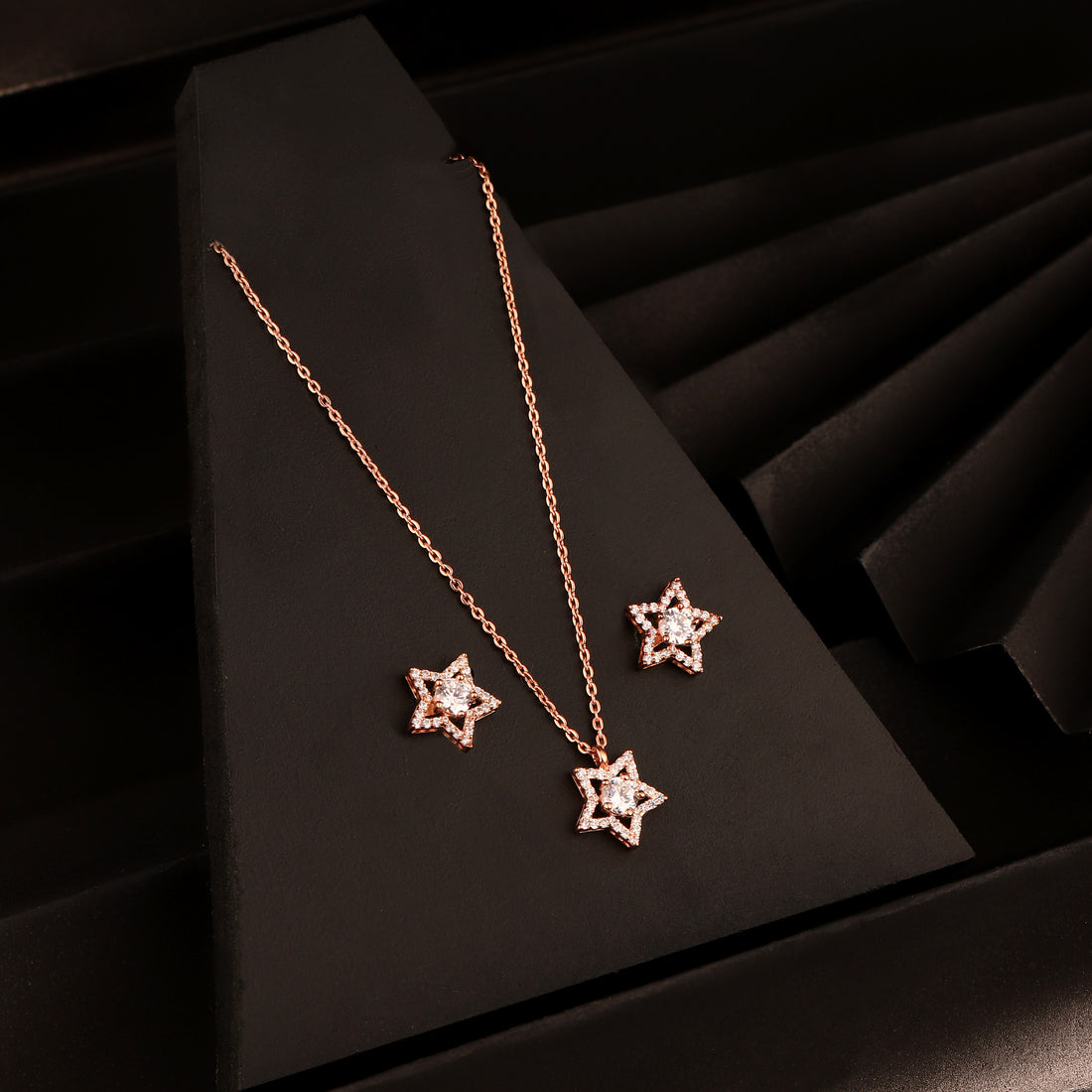 925 silver rose gold star pendant necklace set with matching stud earrings displayed on black background