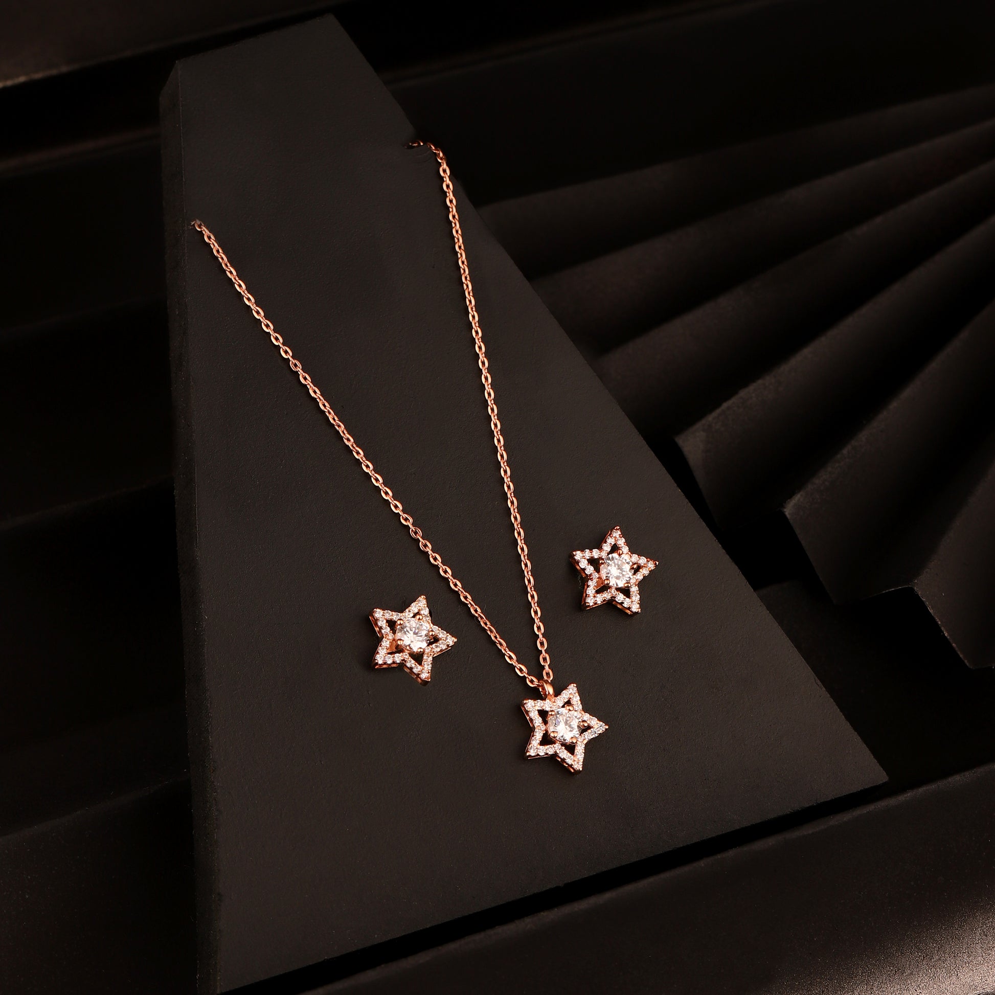 925 silver rose gold star pendant necklace set with matching stud earrings displayed on black background