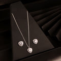 925 silver heart halo pendant necklace set with matching stud earrings on black background