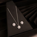 925 silver sunburst pendant necklace set with matching stud earrings on black background