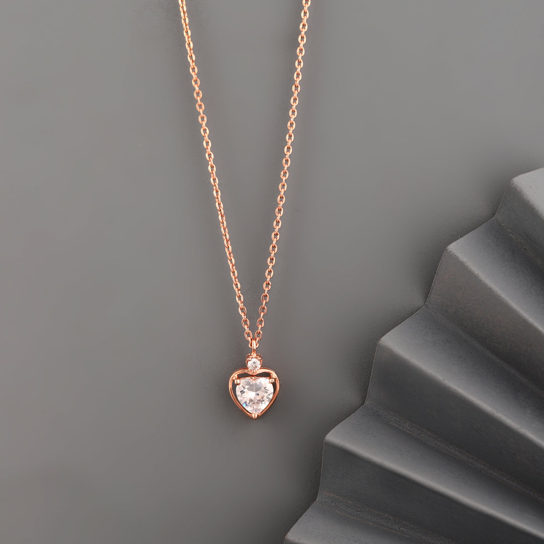 Rose gold 925 silver heart solitaire pendant necklace styled on grey background