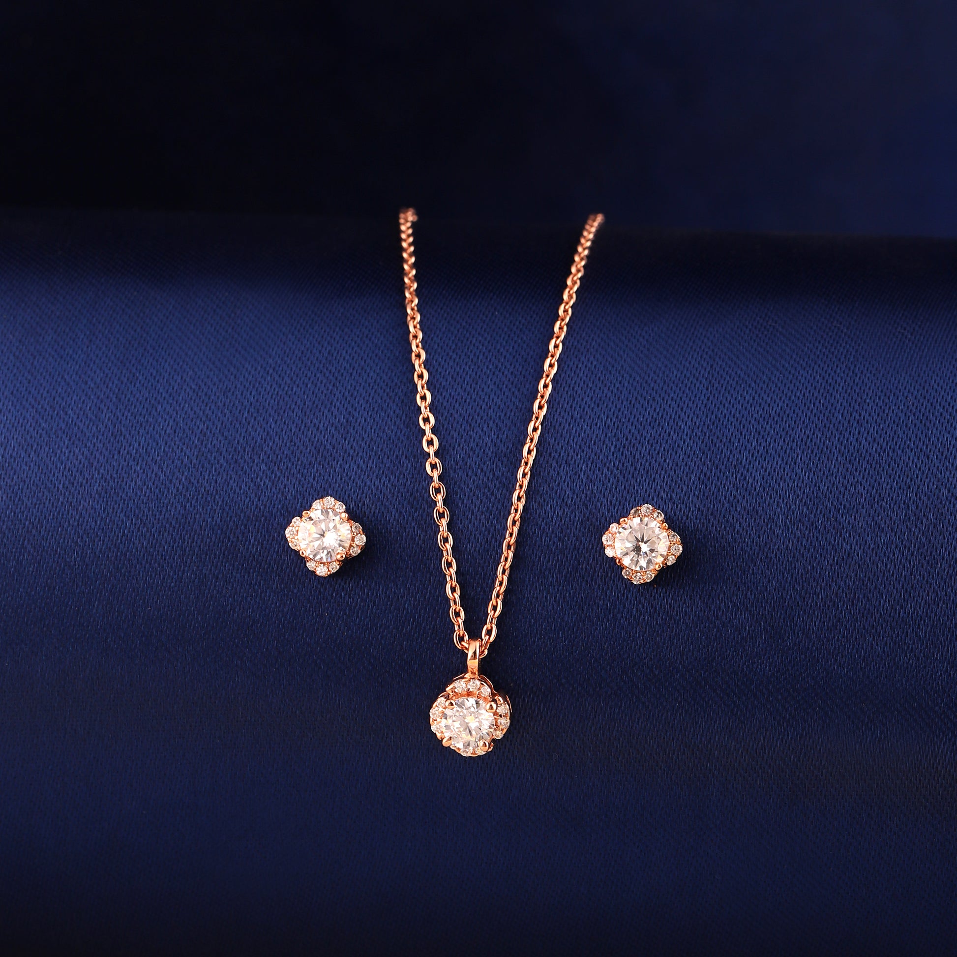 Rose gold 925 silver cushion halo pendant set displayed on blue fabric background