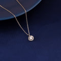 Round halo pendant necklace in 925 silver displayed on blue fabric background