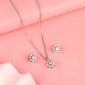 Floral 925 silver pendant and earrings styled on soft pink background