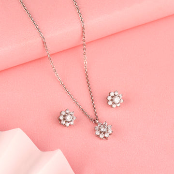 Floral 925 silver pendant and earrings styled on soft pink background