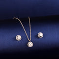 Round halo 925 silver pendant and earrings styled on dark background