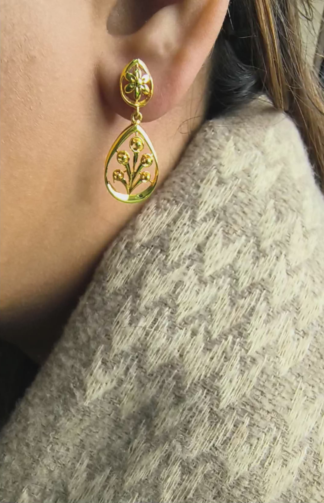 Close-up of 925 silver golden blossom botanical teardrop earrings worn on ear showing elegant nature-inspired drop silhouette